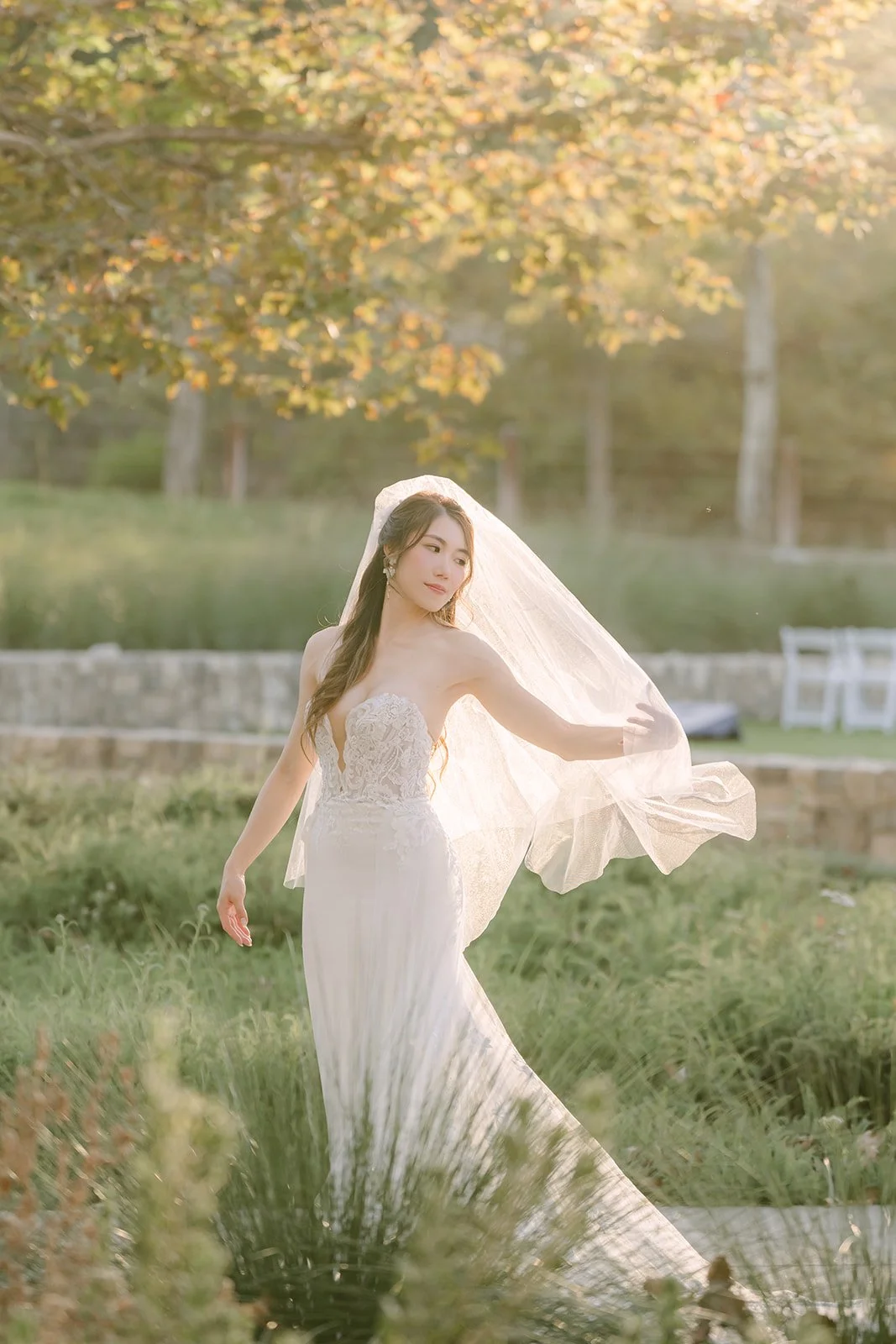 Christie's veil floating behind her as she walks across the lawn.
