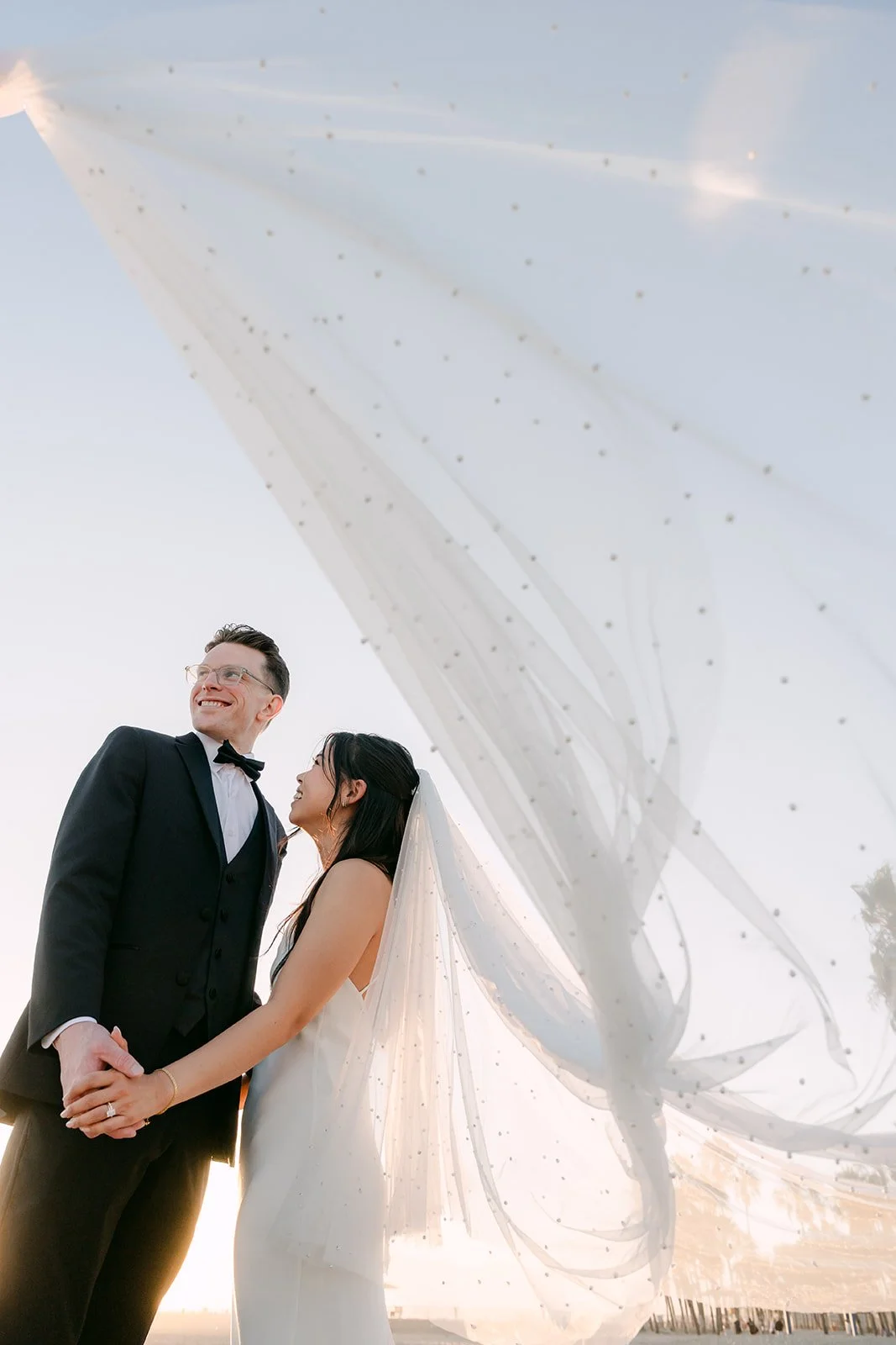 Matthew and Justine laughing under the veil