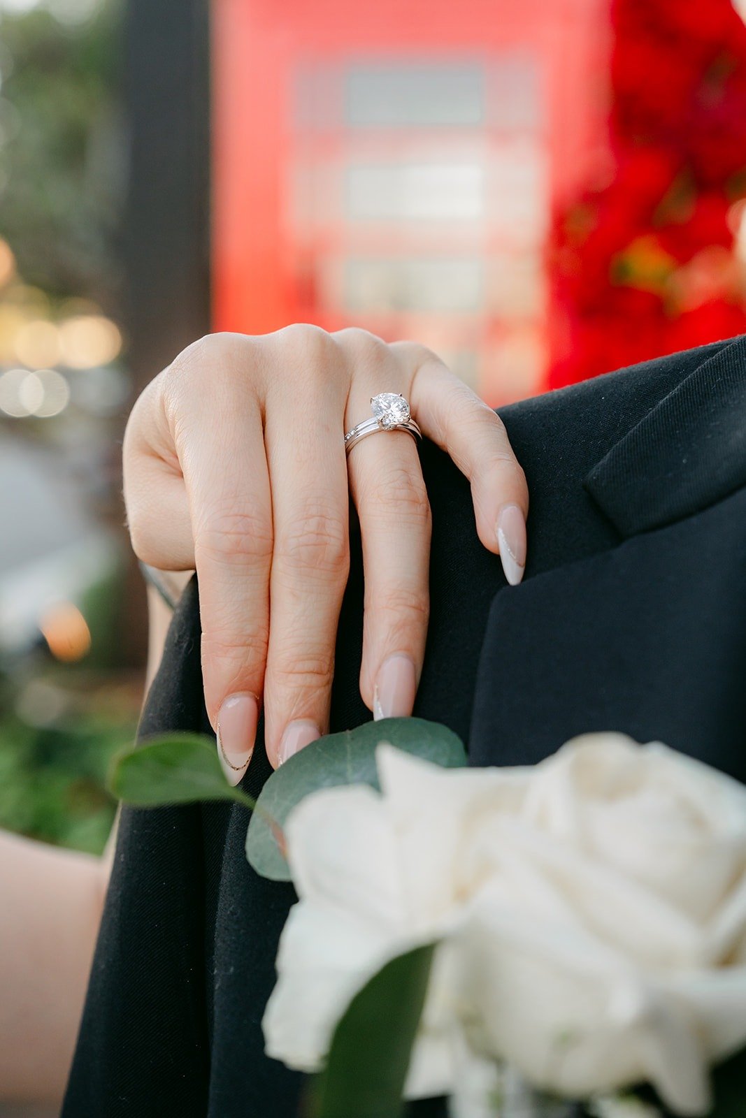 Close up of Valerie's ring on Jason's shoulder with his white boutonniere