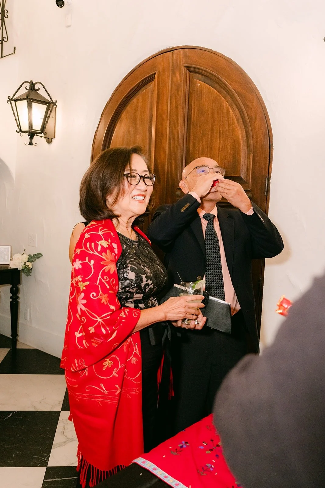 A guest in red celebrating at the door greeting