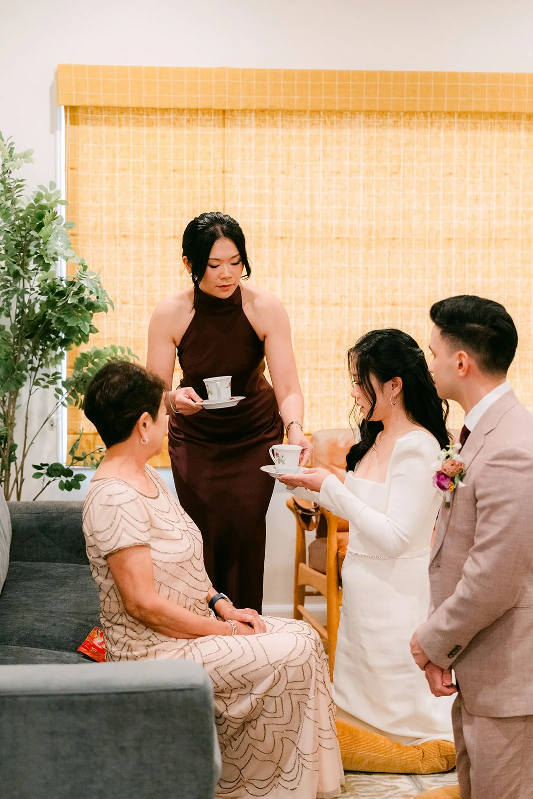 Denise and Michael serving tea to Denise's mom while her sister holds the tray.