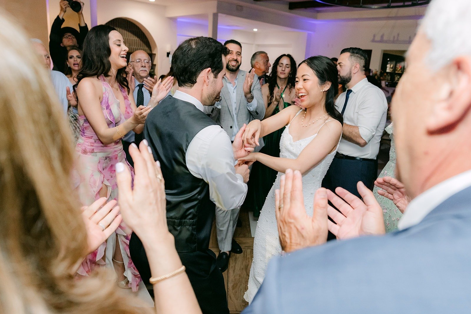 Guests clapping as Stephanie dances in the middle of the crowd