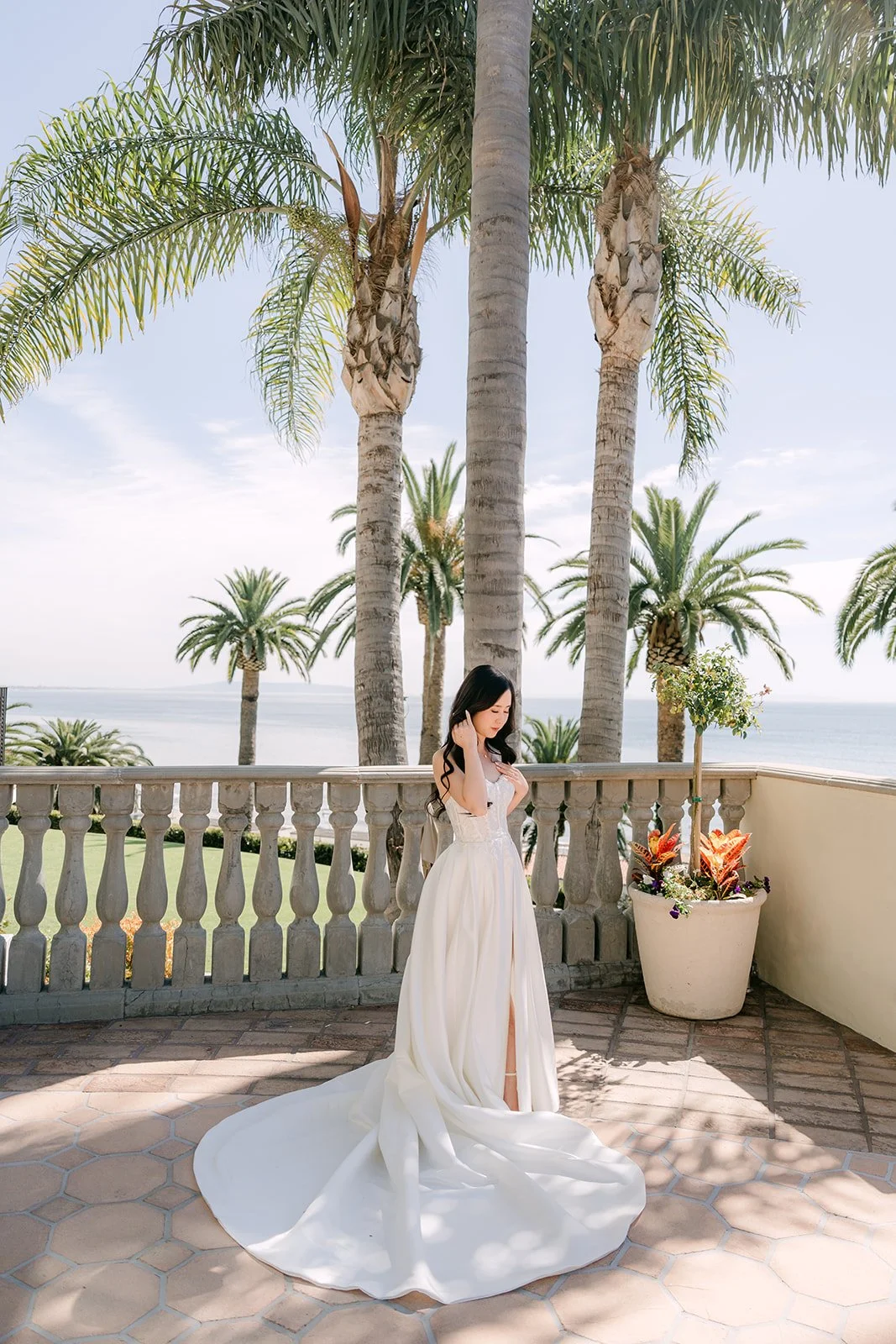Bride in her strapless gown on the palm-lined terrace at Bel-Air Bay Club