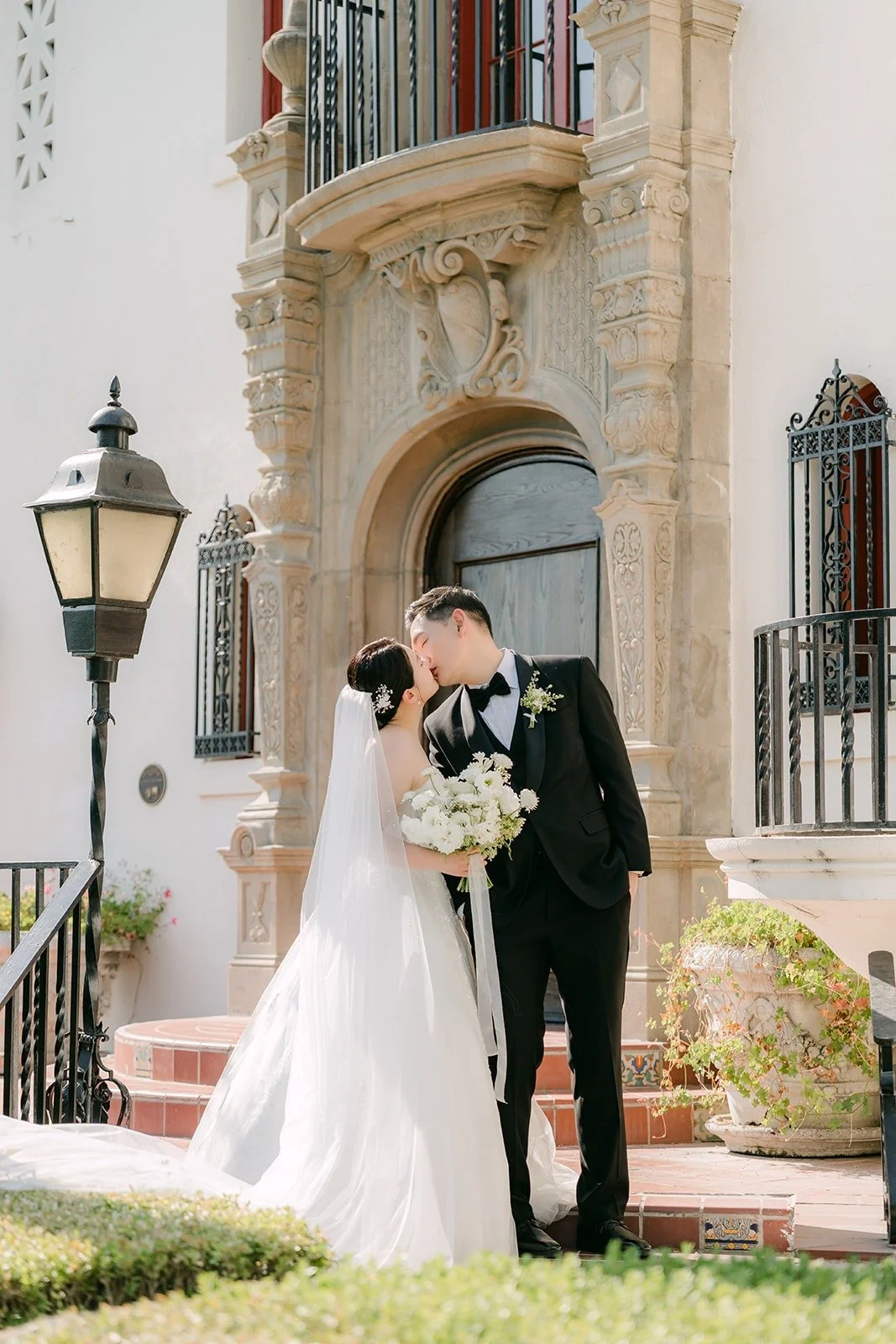 Amy and Sam kissing at the carved entrance of the mansion