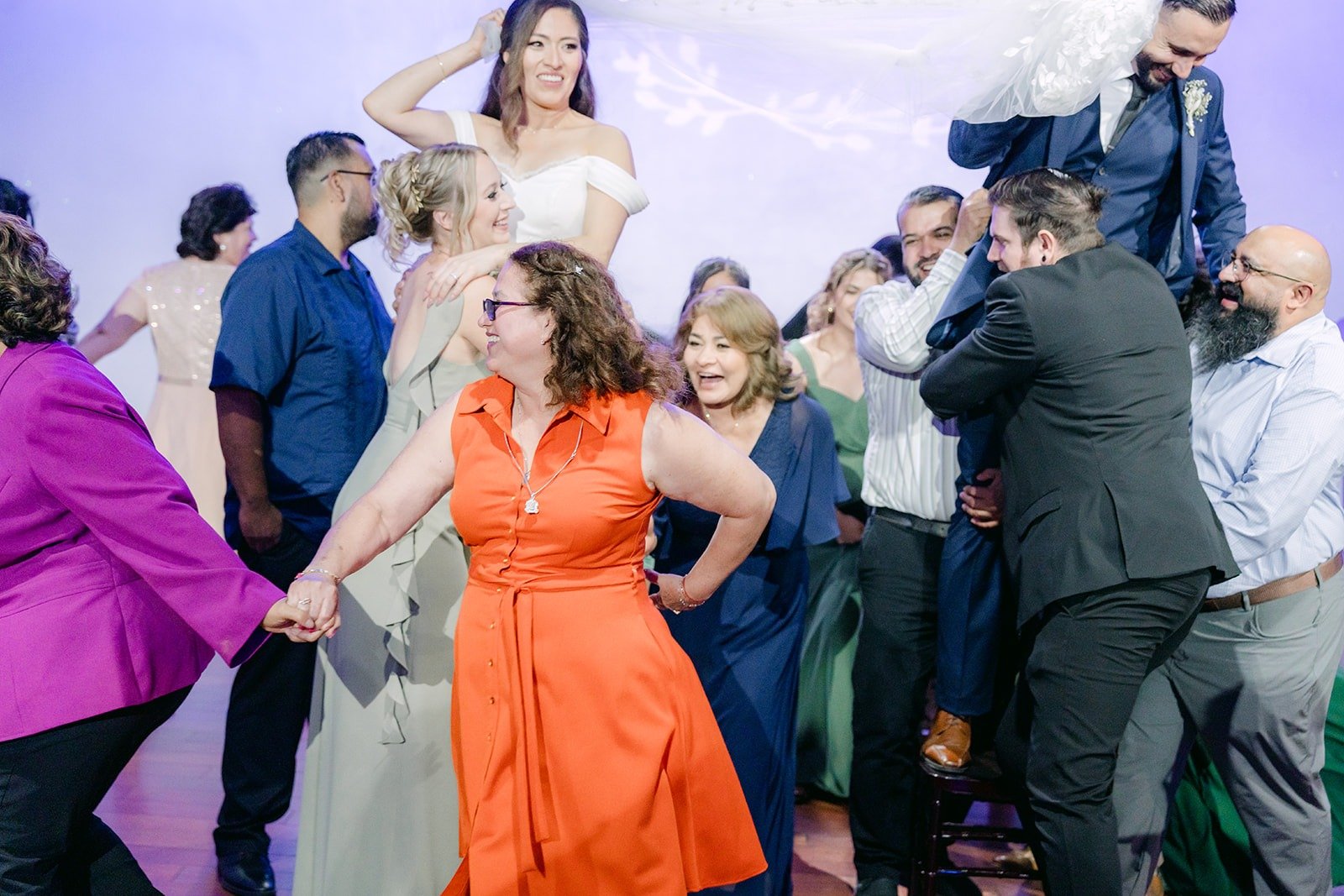 Guests and the wedding party cheering during a reception game