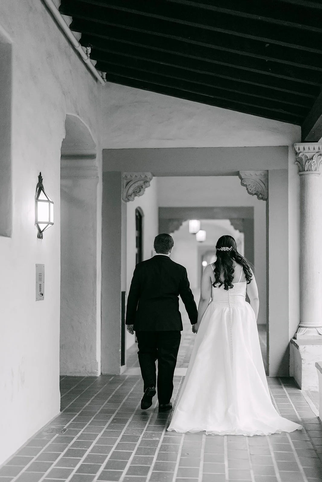 Saira and Matthew walking through a tiled corridor at The Athenaeum