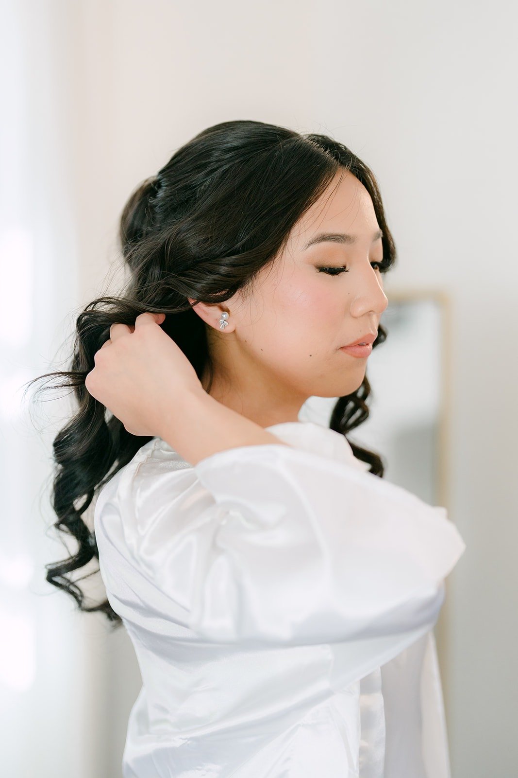Kelli in her robe touching her curled hair in the Bridal Suite