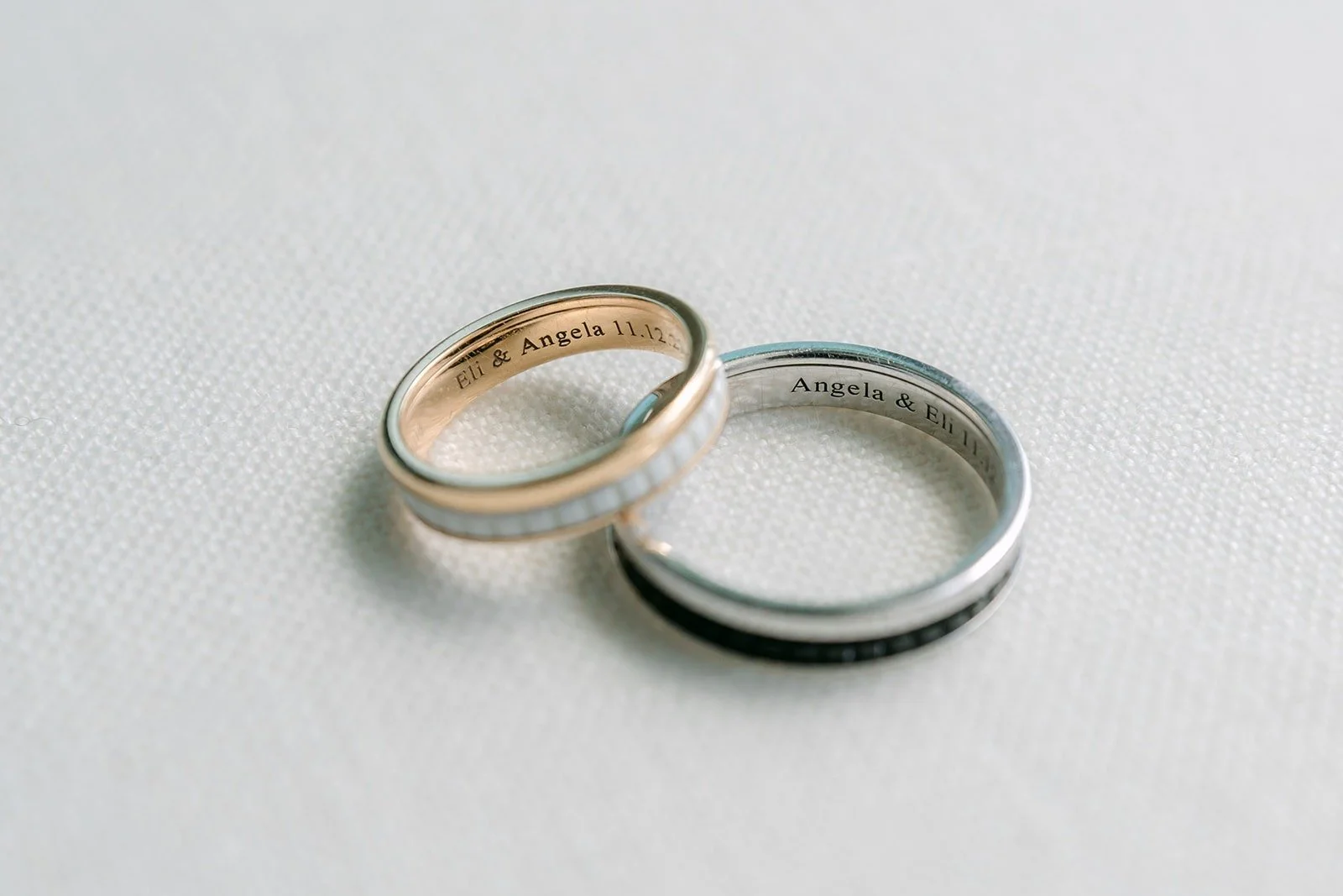 Angela and Eli's wedding bands side by side on a white backdrop
