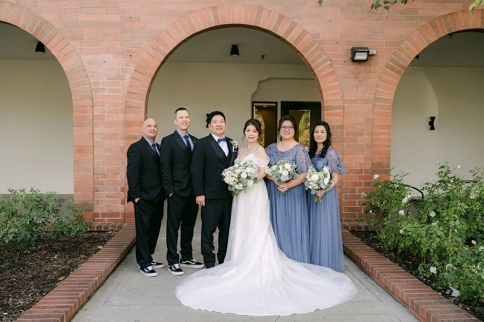The wedding party lined up under the brick arches at Sierra La Verne