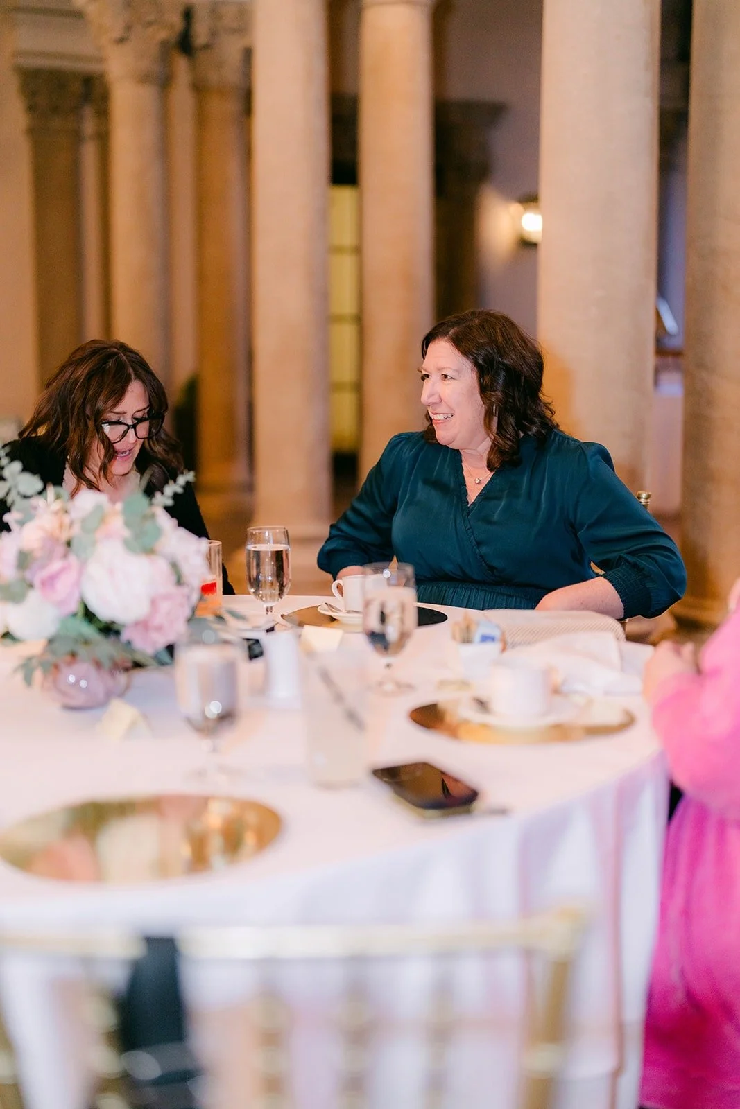A guest smiling at her table during the reception