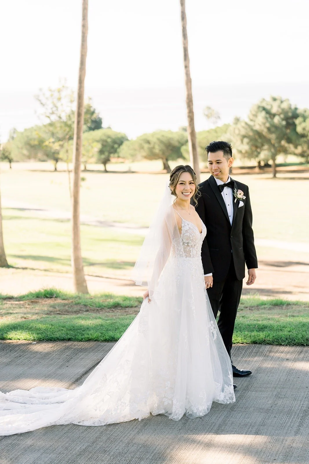 Josephine and David standing on the path between the palms
