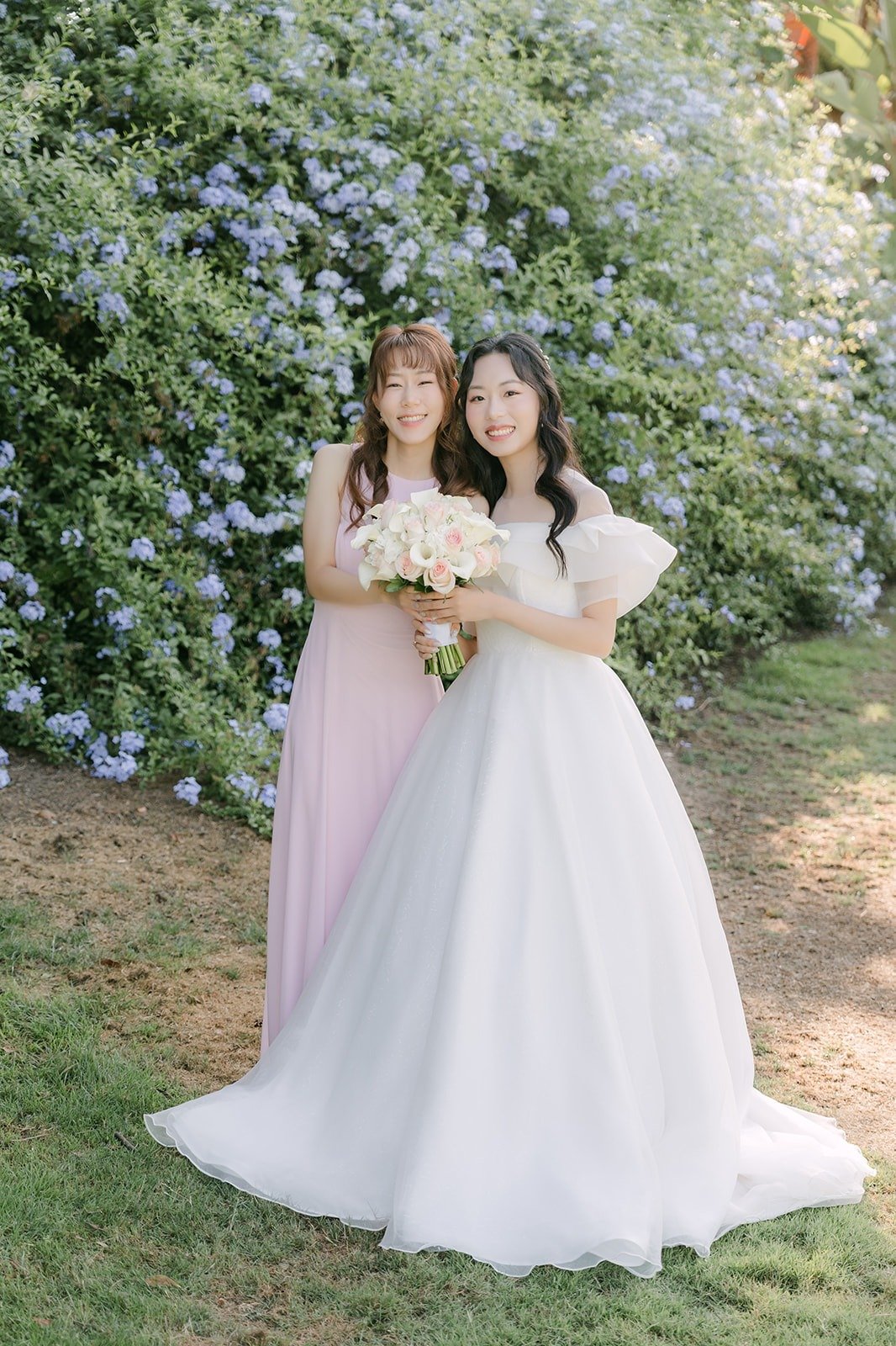Jeannie and her maid of honor laughing with their bouquets, photographed by One and Only Production