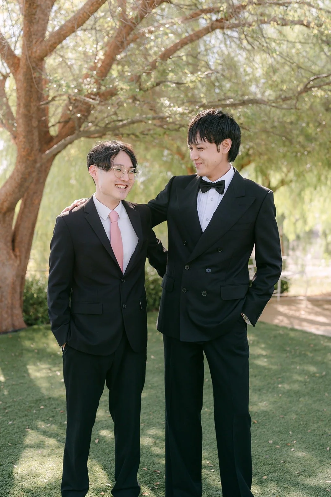 Job and his best man laughing under the oak trees