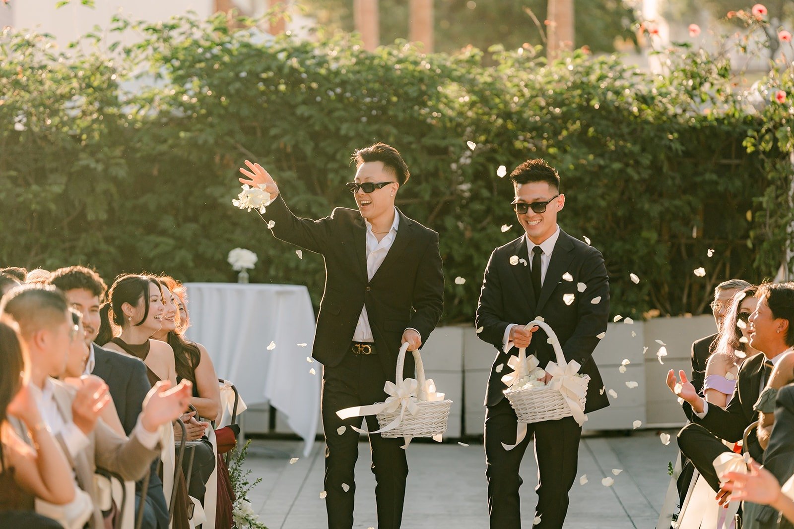 The two adult flower boys in sunglasses tossing petals down the aisle