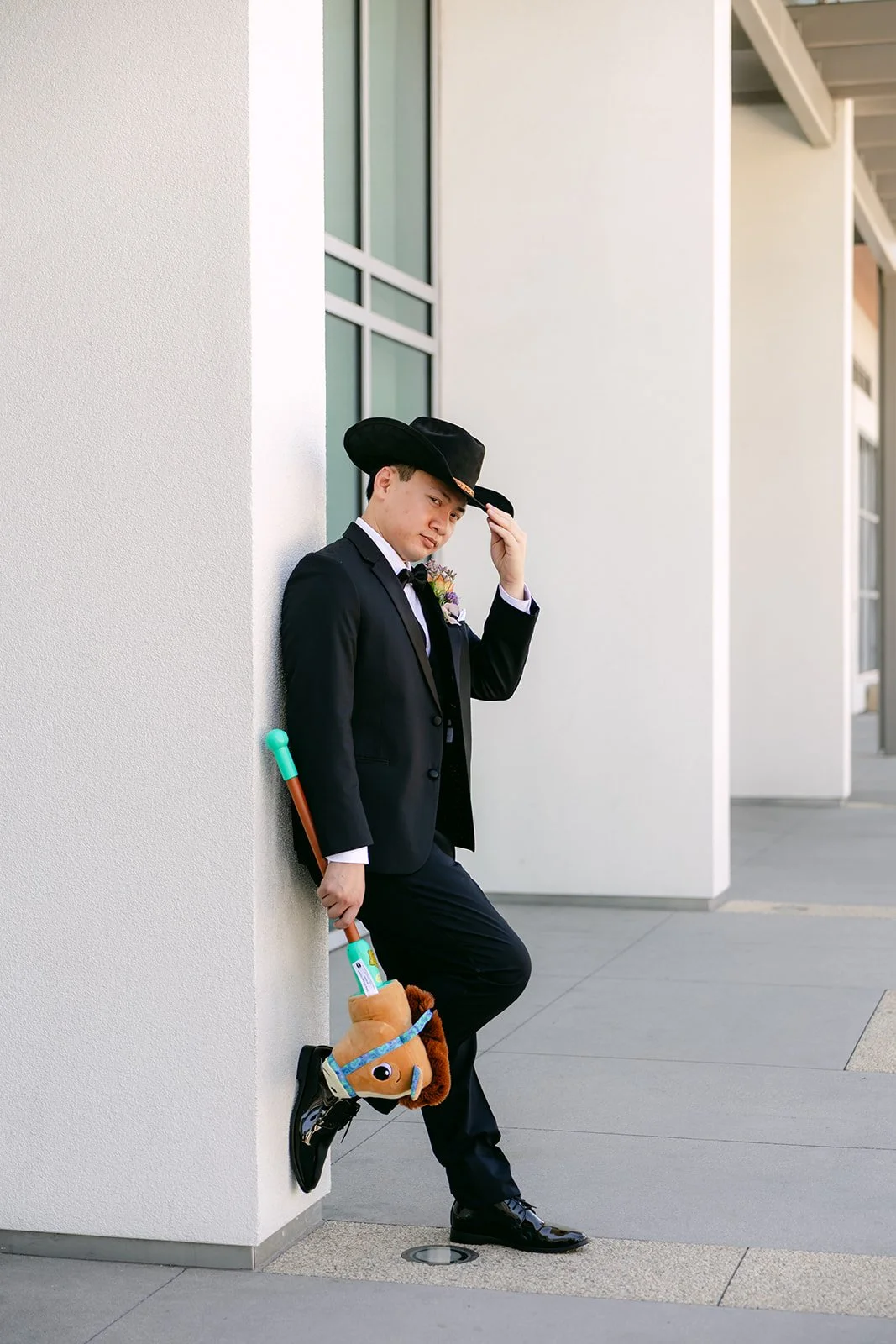 Hoan in a cowboy hat leaning against a white column outside the hotel