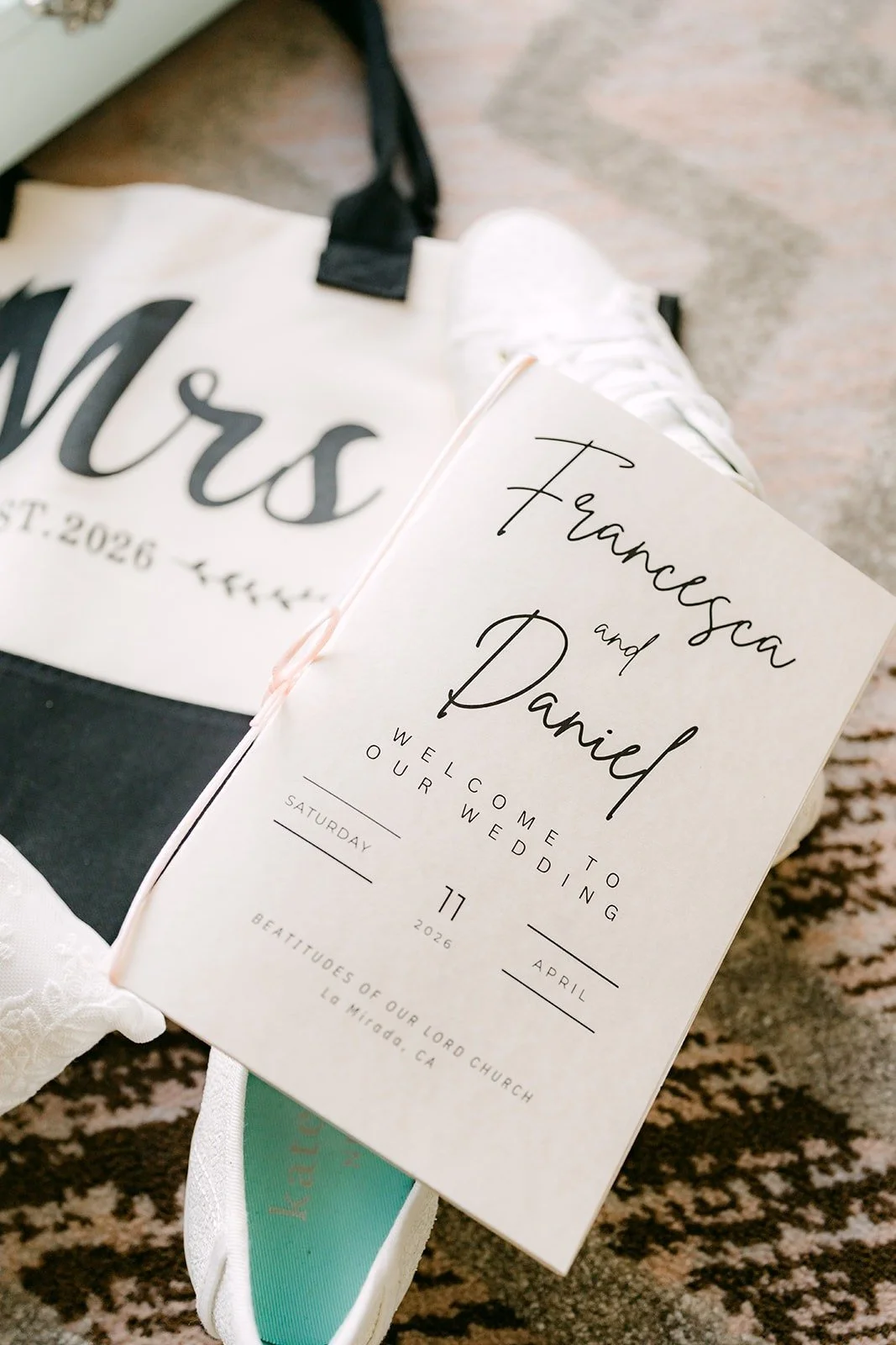 Francesca and Daniel's invitation laid over a black Mrs tote bag