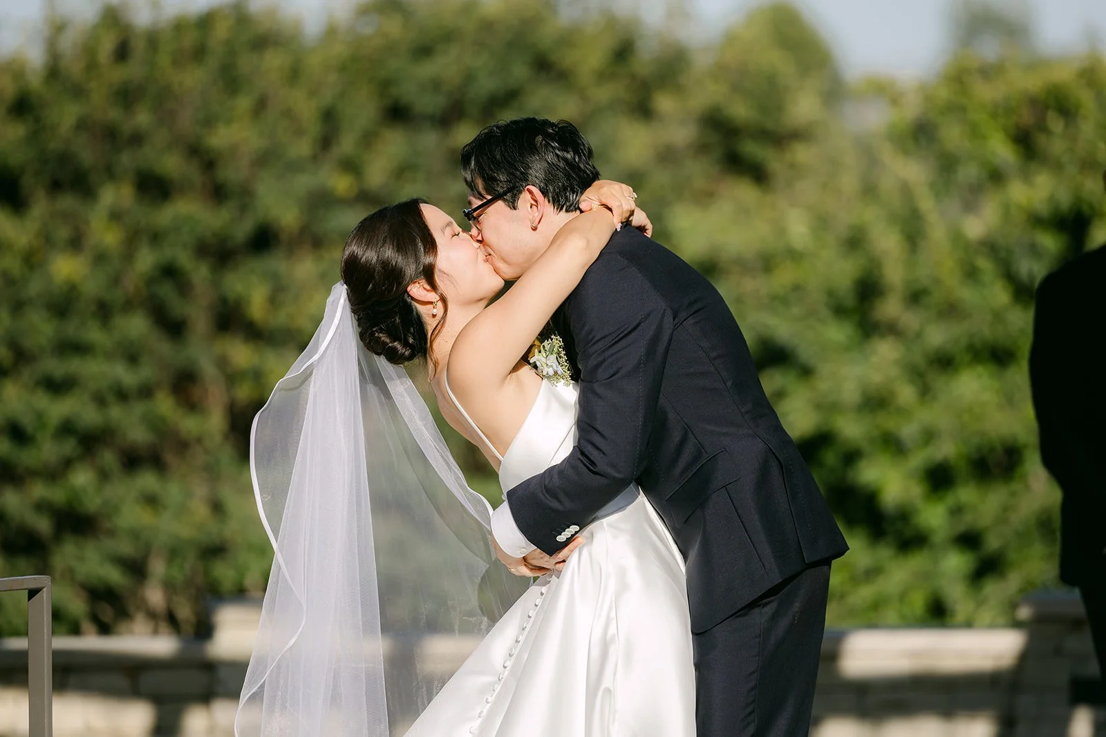 The first kiss as husband and wife beneath the floral arch