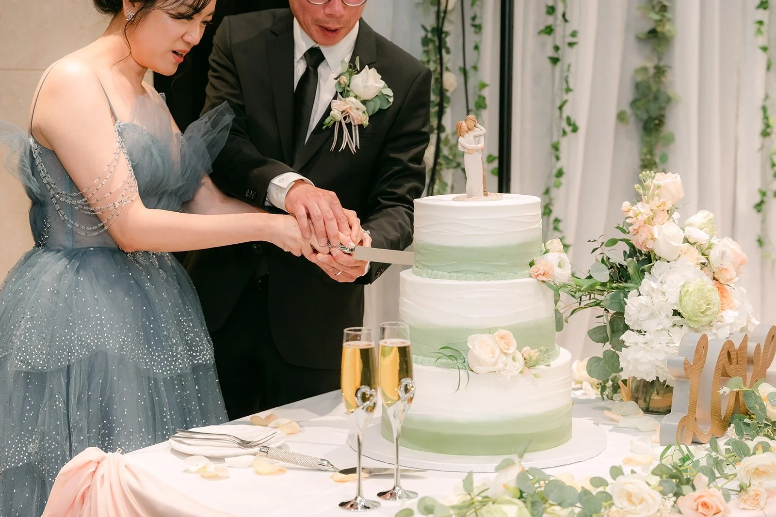 Eunice and Eric cut their tiered wedding cake together