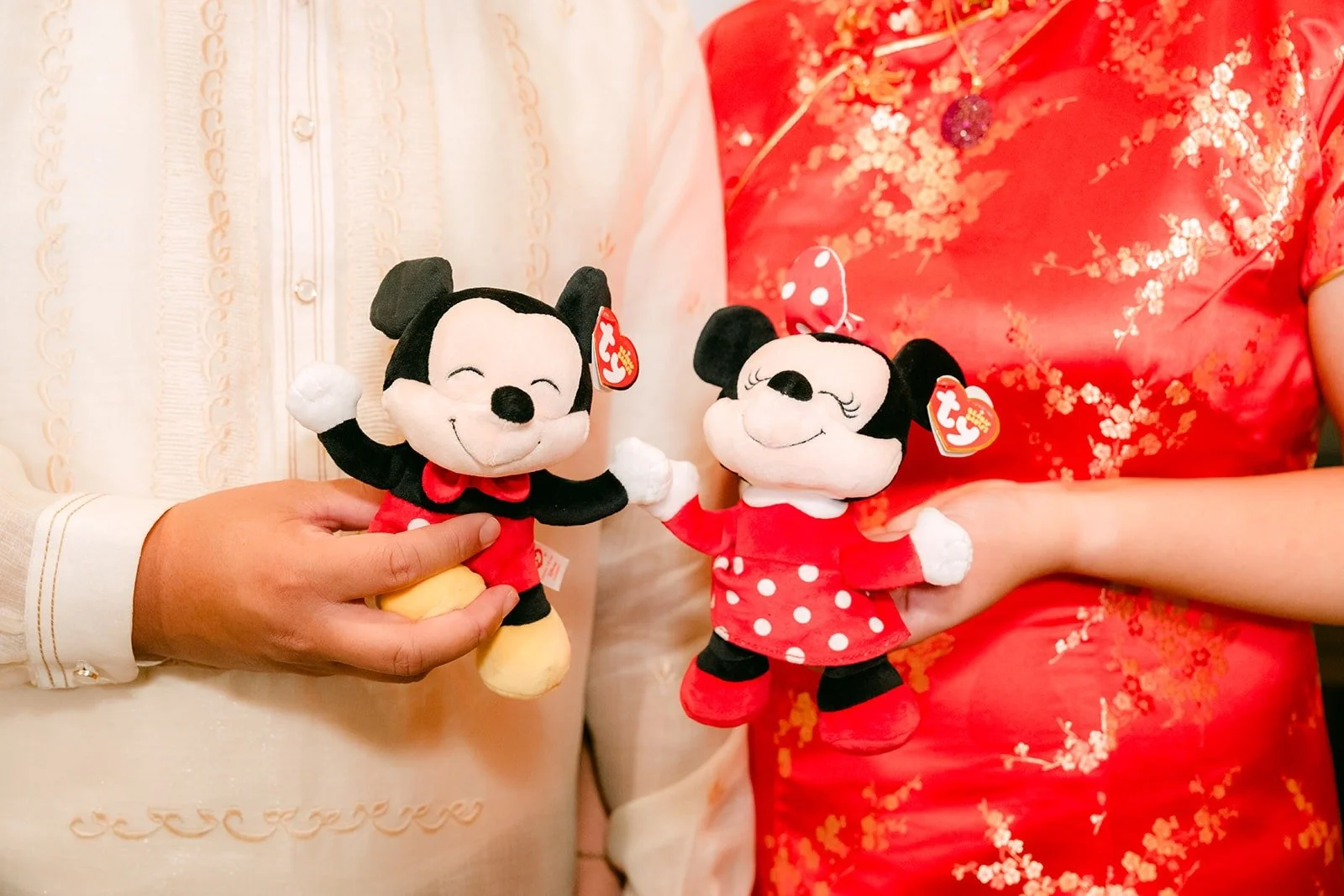 Stella and James holding Mickey and Minnie plush toys dressed in red, photographed by One and Only Production