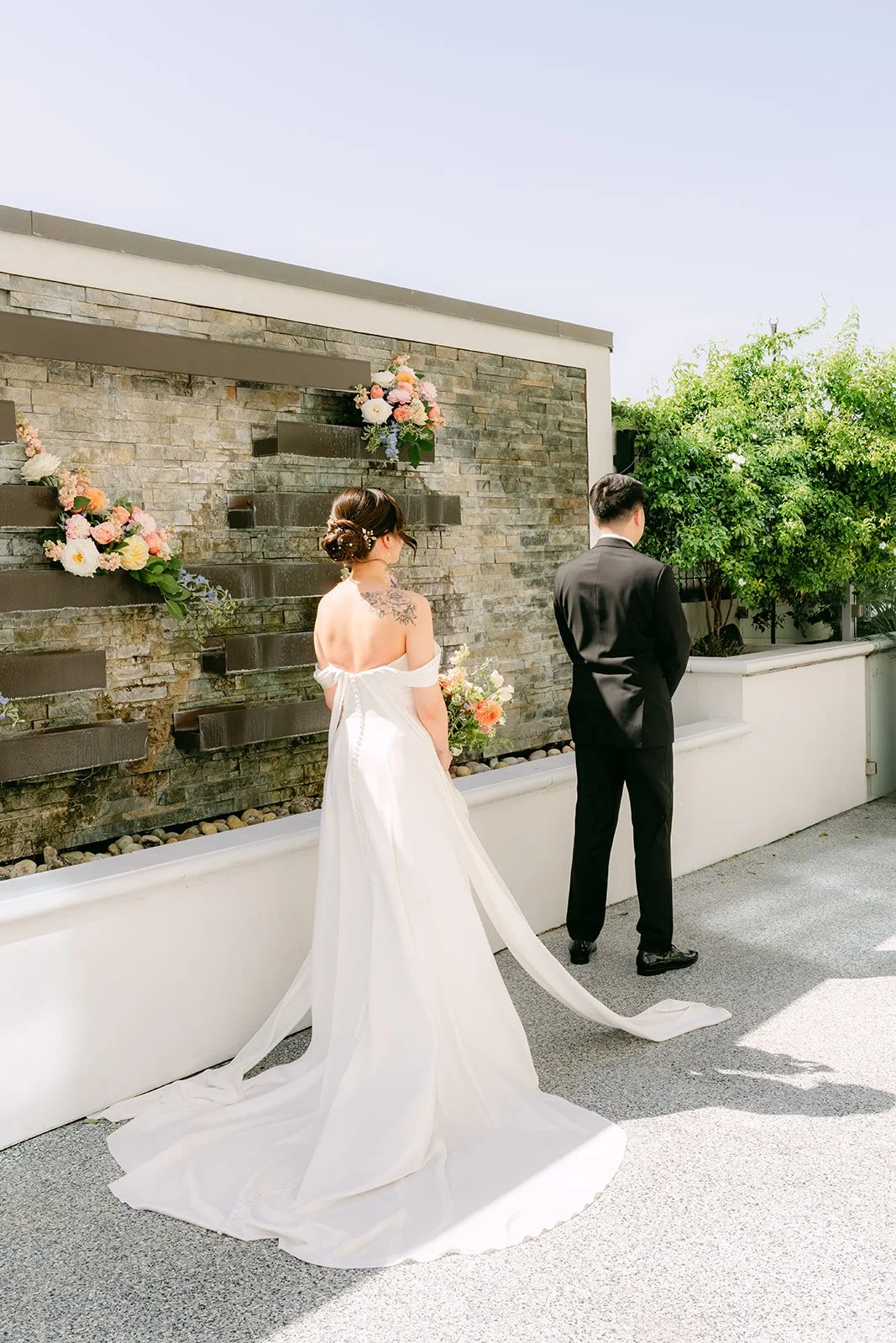 Amanda in her gown and veil approaching San from behind.