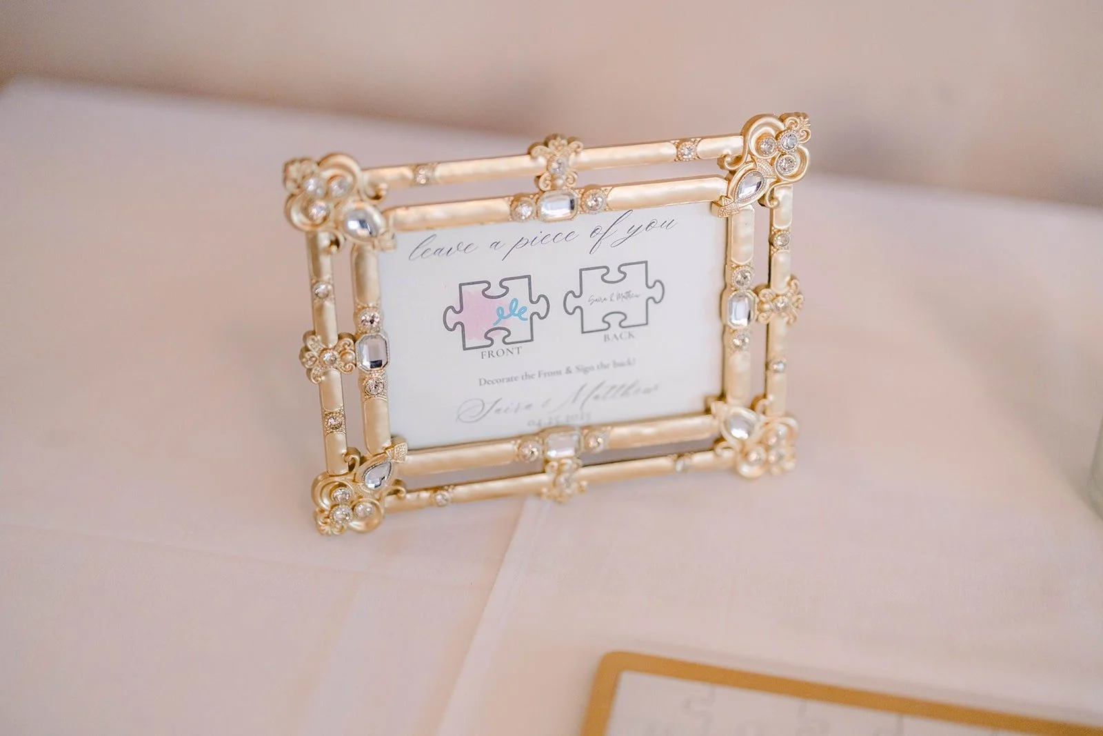 A gold framed table card on white linen