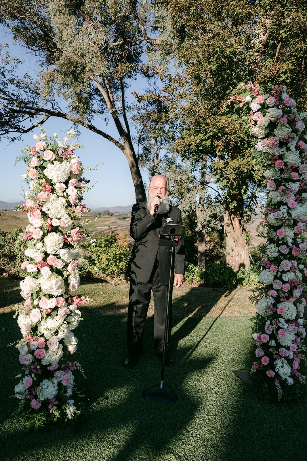 The officiant waiting between the floral columns
