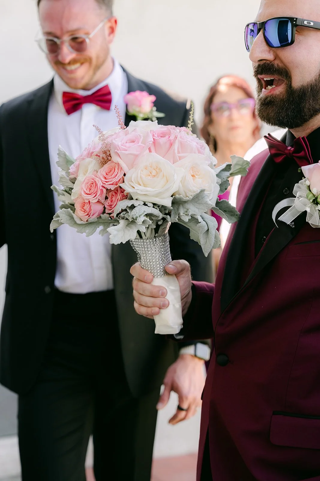 Ryan smiling with Vanessa's pink bouquet, photographed by One and Only Production.