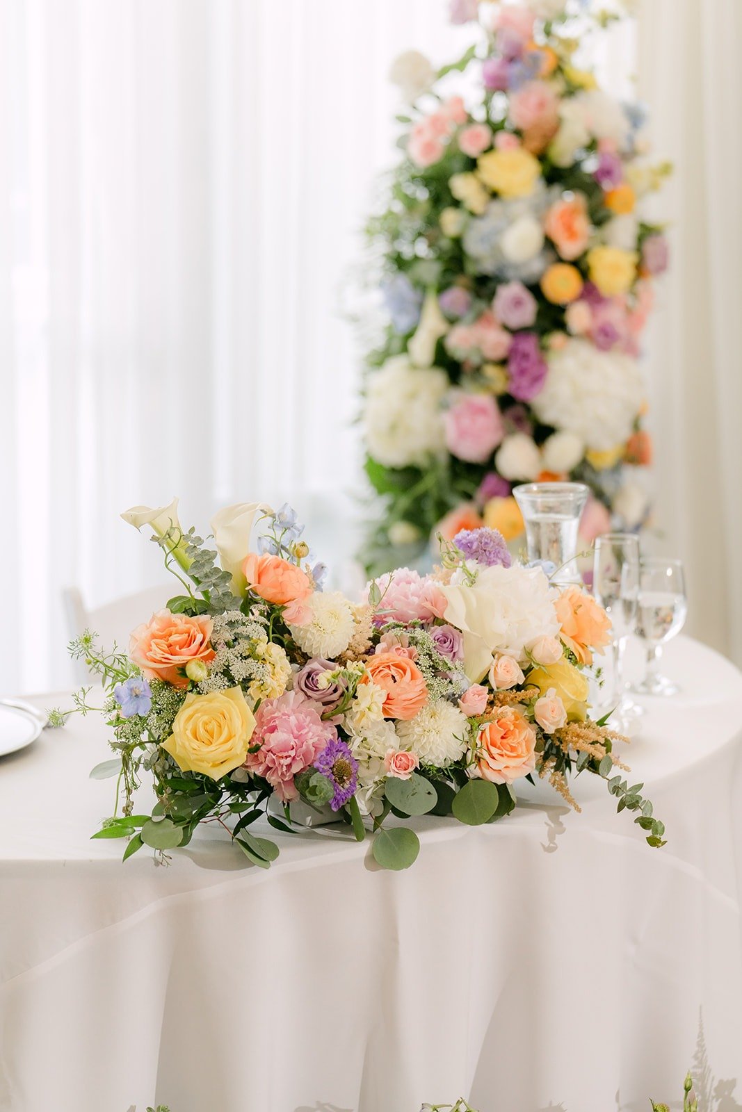 The sweetheart table florals in peach, yellow and lavender