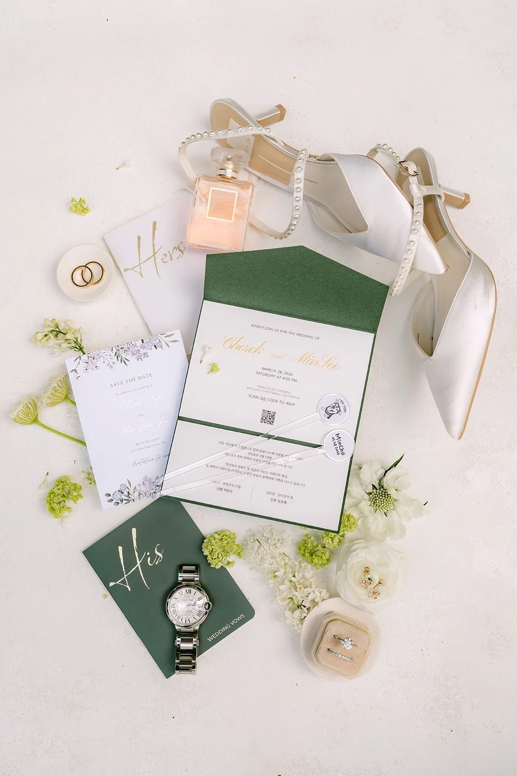 Chorok and Min Soo's wedding invitation suite styled with a ring box, a watch and white blooms