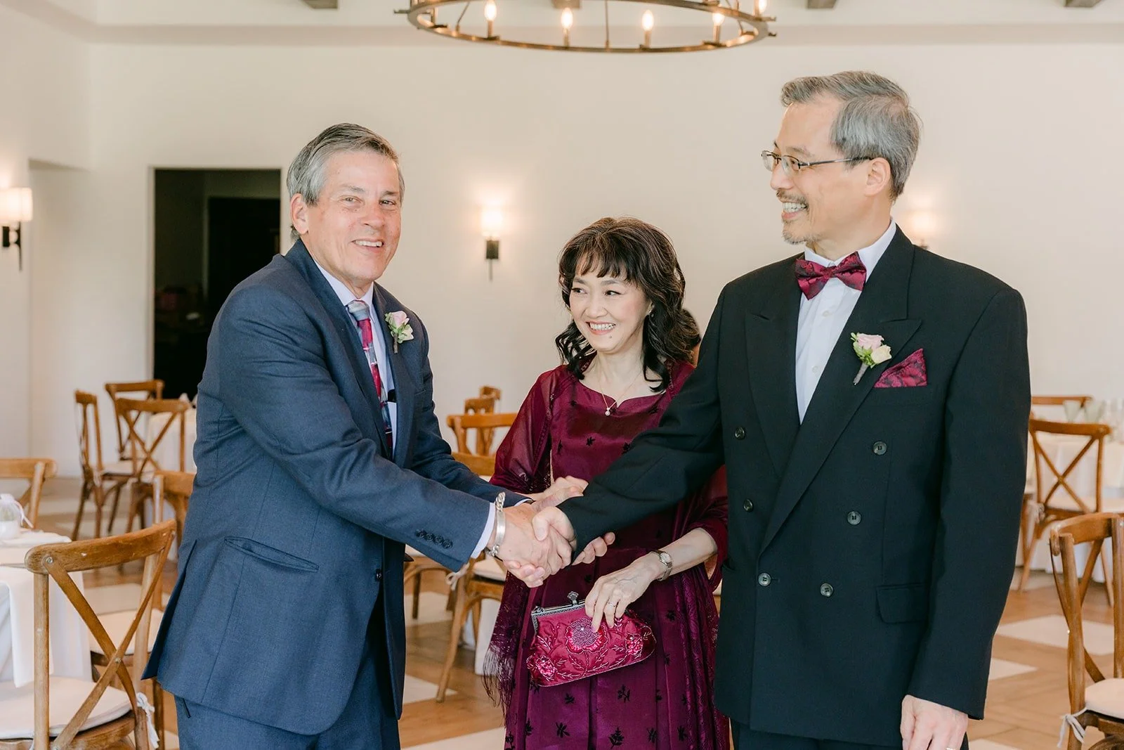 Two family members shaking hands inside the reception room, photographed by One and Only Production