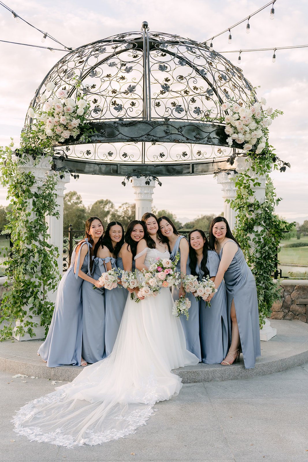 Jessica with her bridesmaids in dusty blue at the gazebo