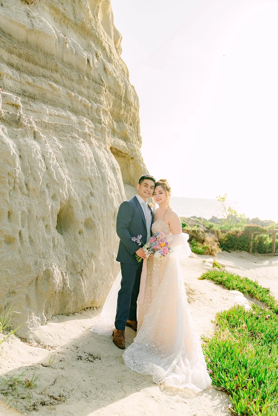 Joanna and Jerrick on the sand beside the cliffs, photographed by One and Only Production