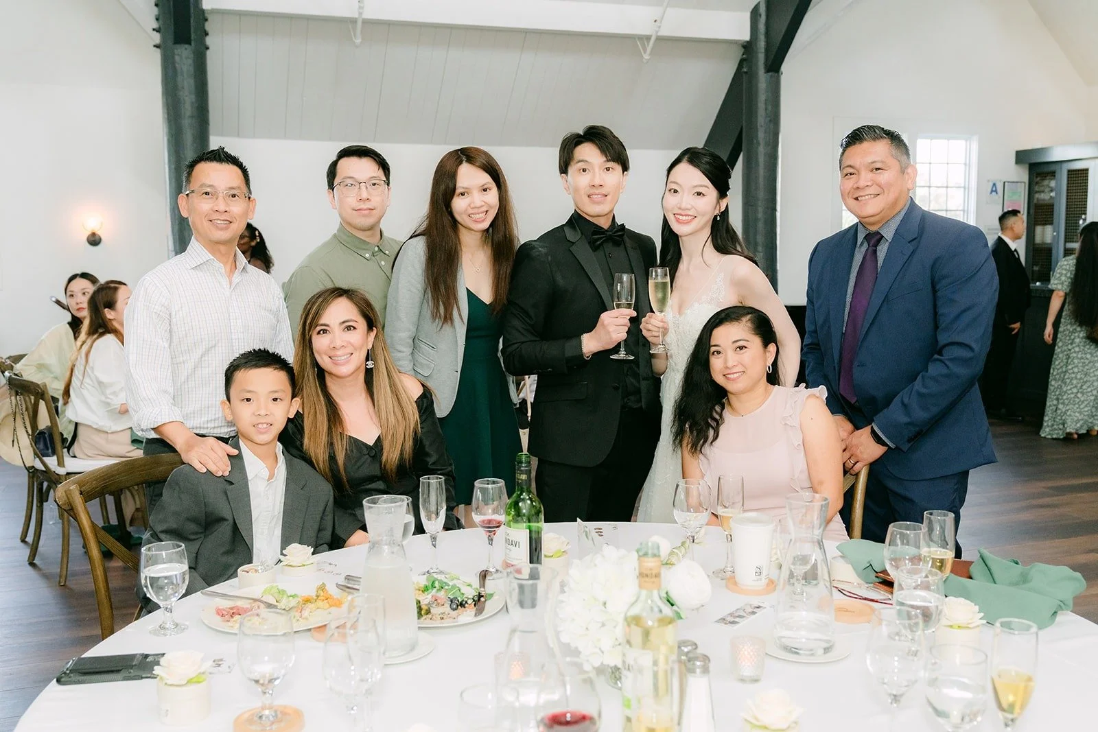 Tin and Fong posing with a table of guests