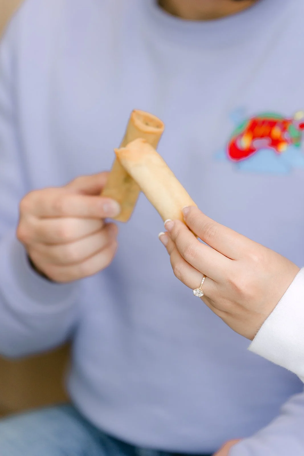 Close-up of Linh's engagement ring as she holds an egg roll.