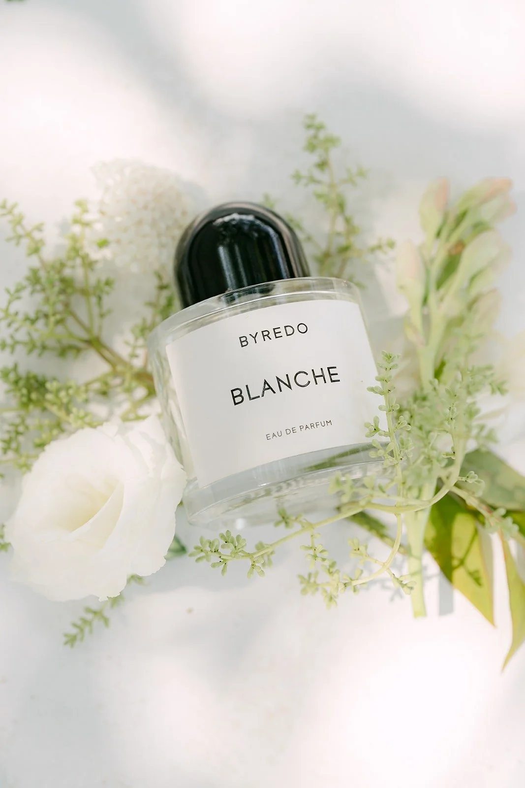 Byredo Blanche perfume among white roses