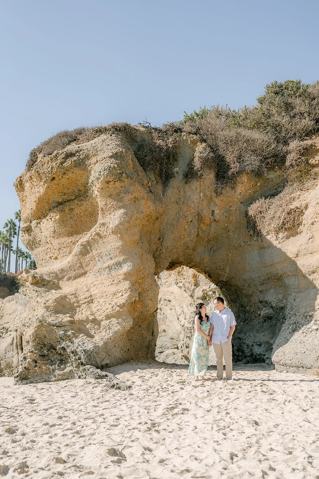 Wide view of the rock arch with Constance and Lawrence beneath it.