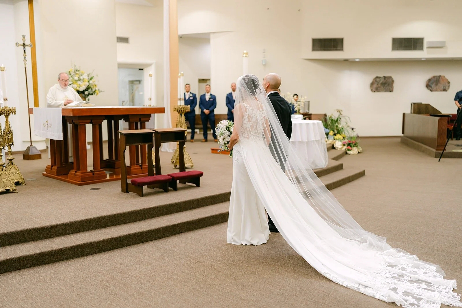 Francesca's long veil trails behind her on the sanctuary steps
