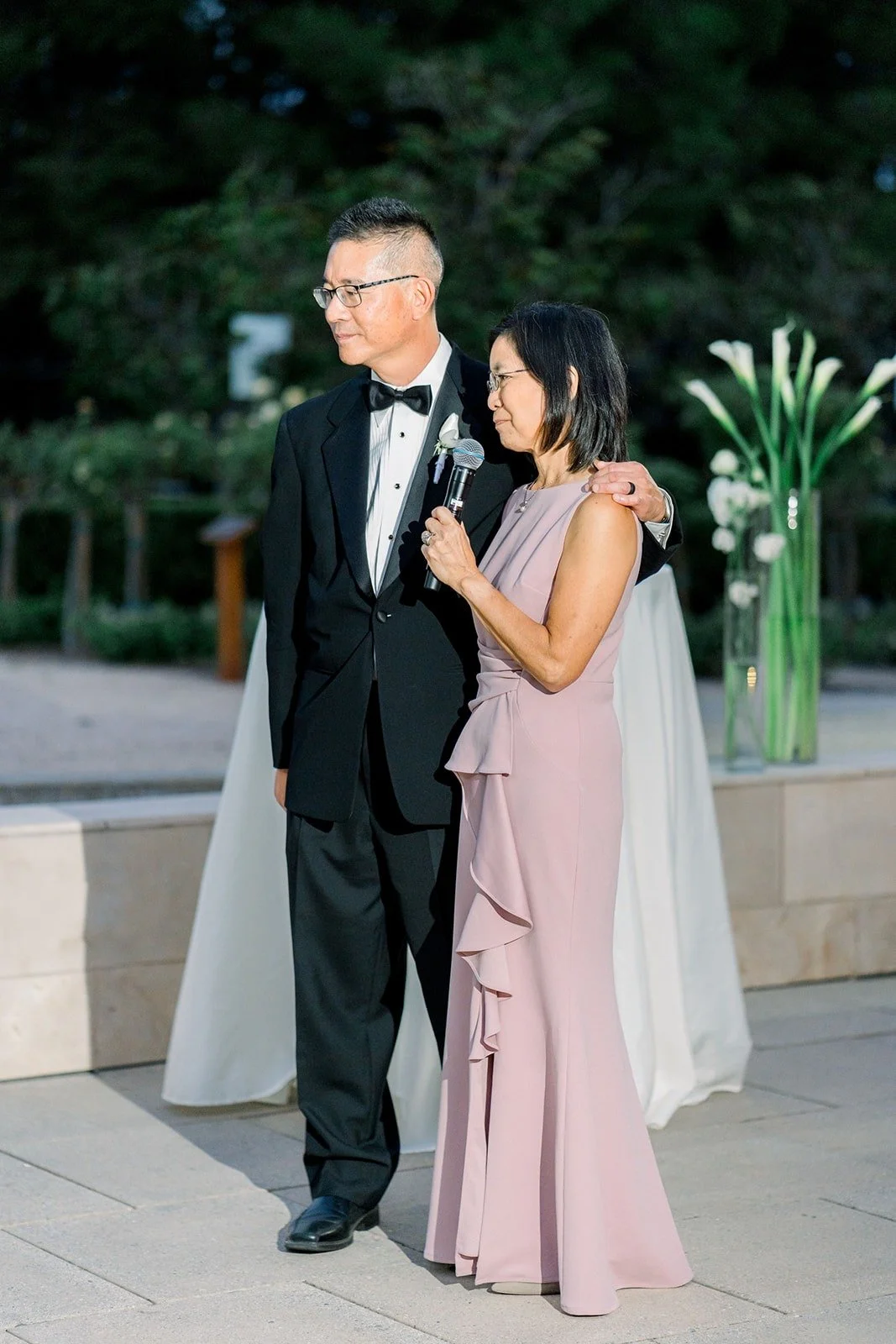 A groomsman and a bridesmaid give a toast together