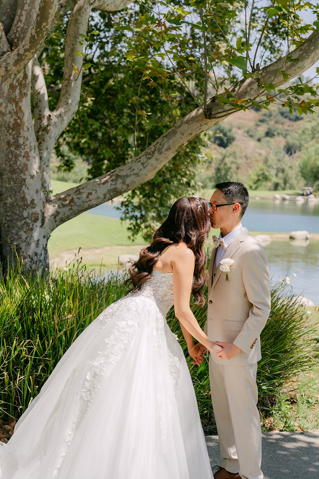 Kevin kissing Sandra under the trees by the lake.