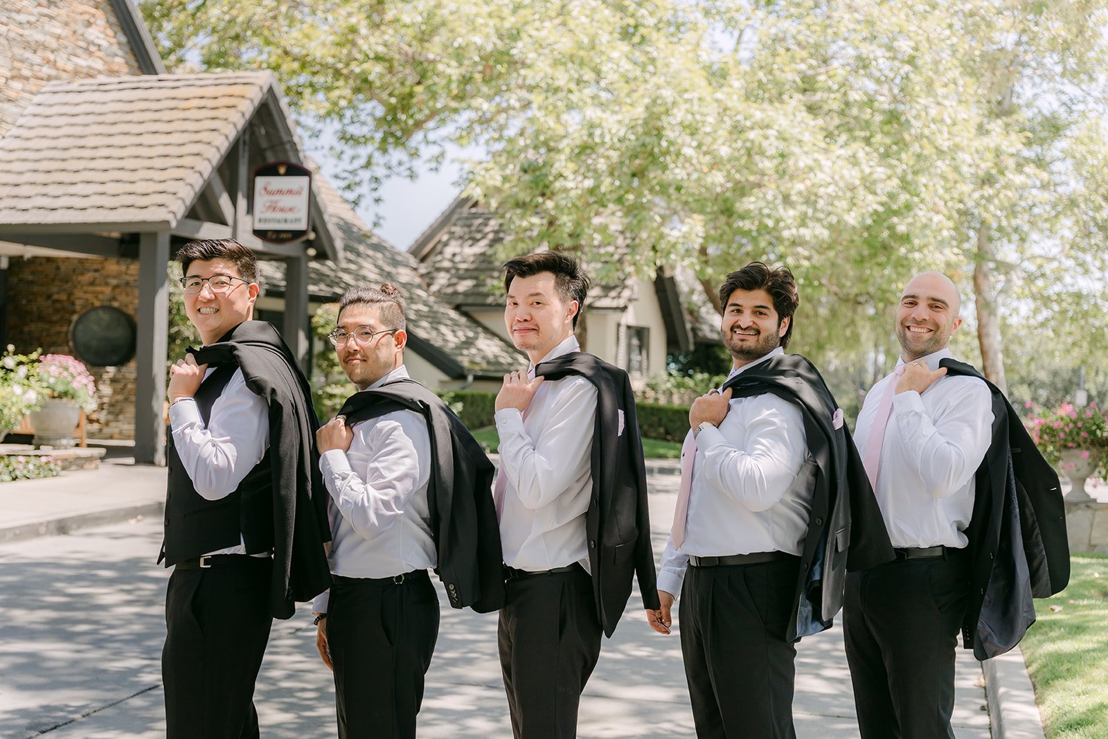 Joshua and his groomsmen lined up in black tuxedos