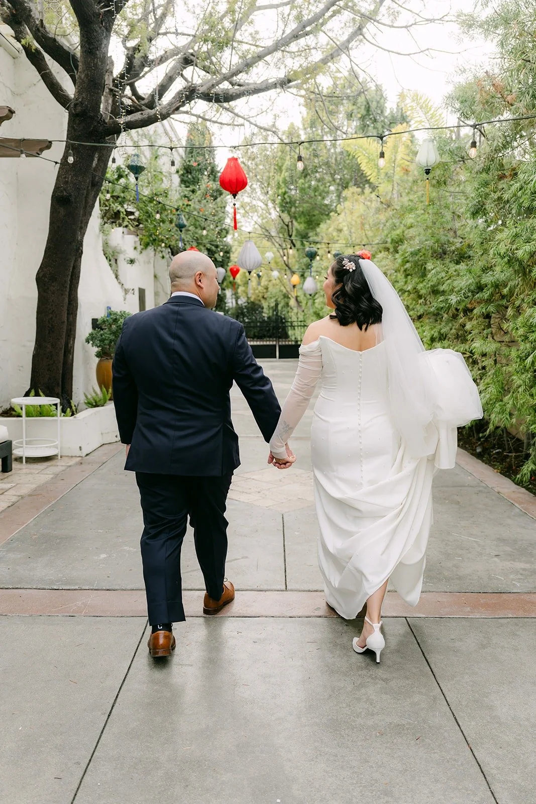 Vivian and Yao walking hand in hand down the path