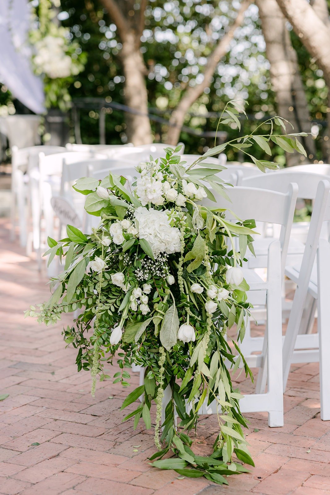 White flowers and greenery marking the end of an aisle row