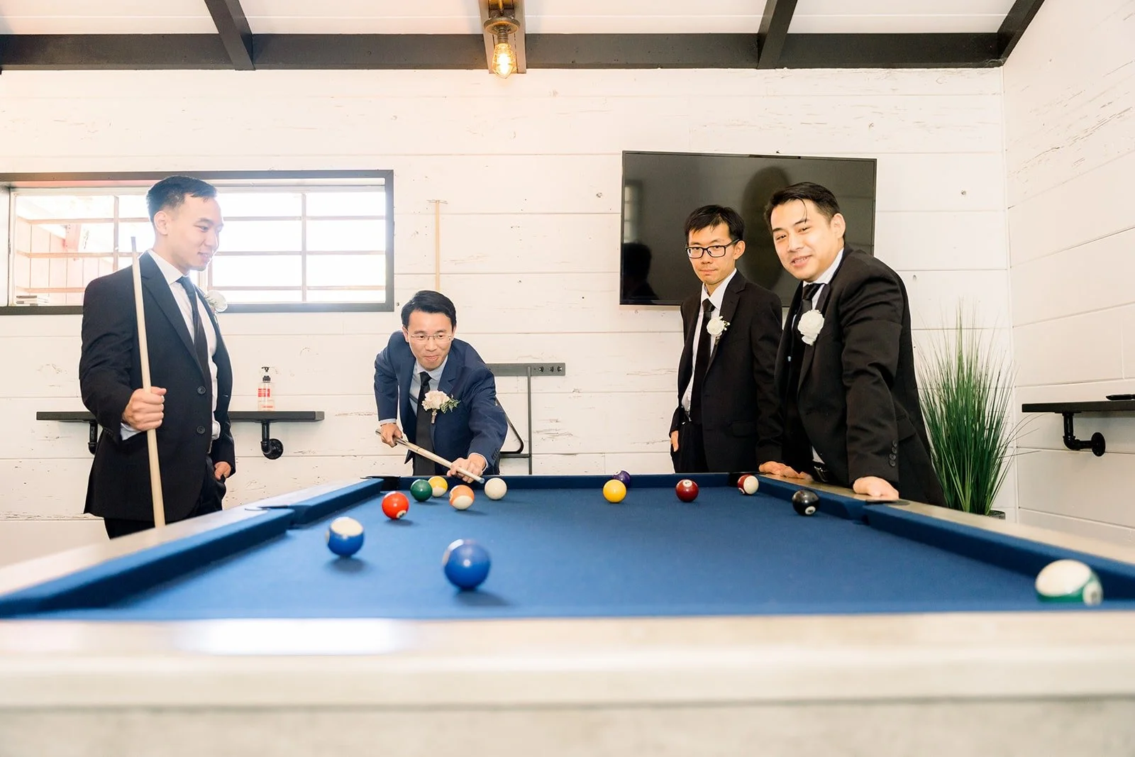 Alex and his groomsmen playing pool before the ceremony, photographed by One and Only Production