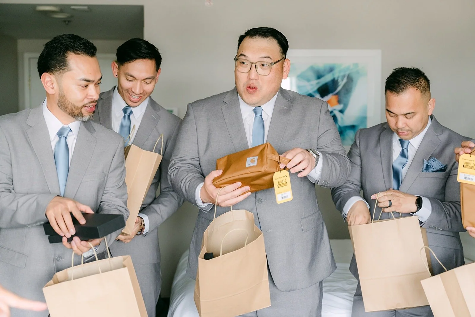Mark's groomsmen opening their gifts from kraft paper bags