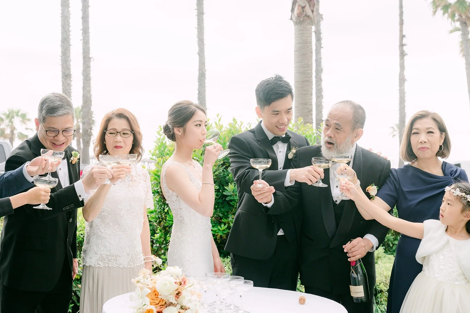 Angela and Eli raising glasses with family members, photographed by One and Only Production