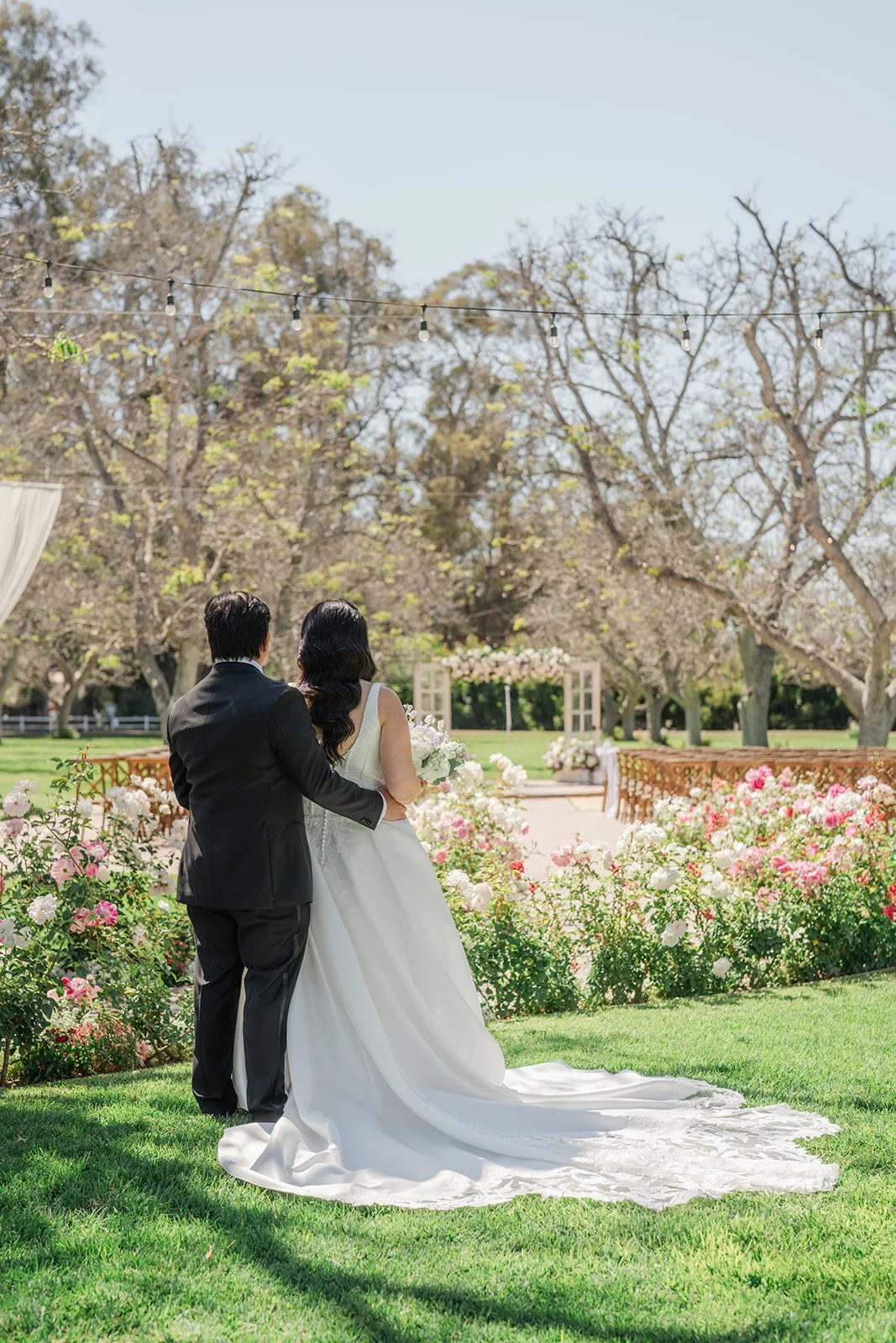 Couple walking through the rose garden after the first look