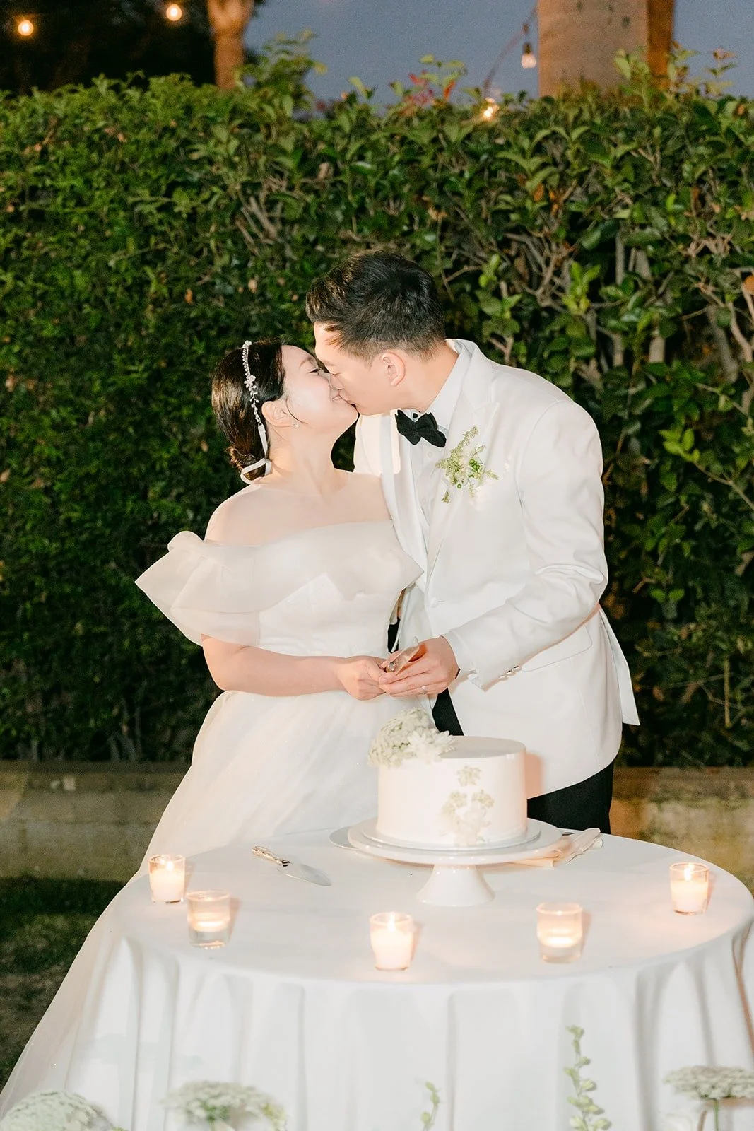 Amy and Sam kissing as they cut the cake