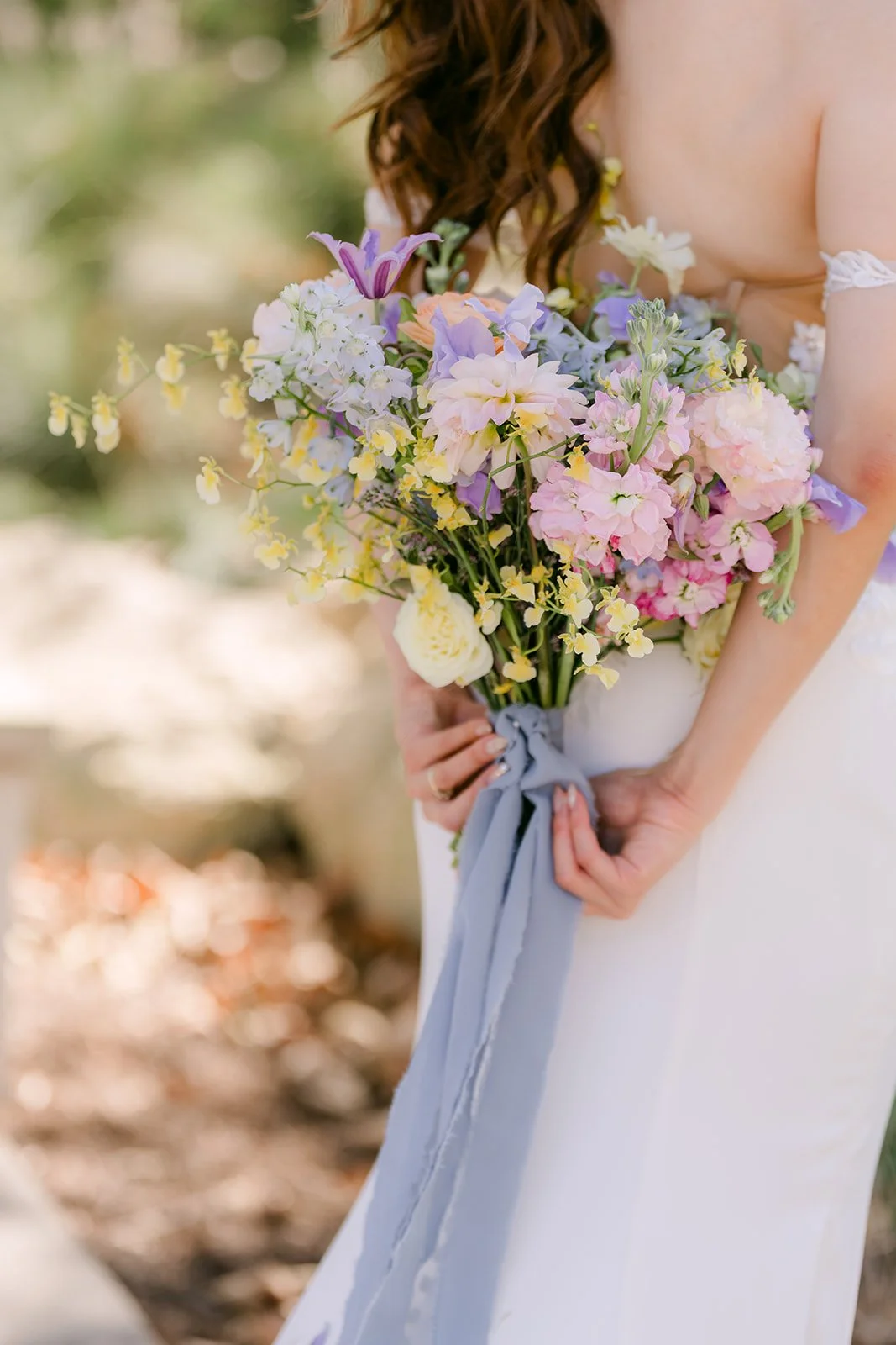 Christie's pastel bouquet with blue ribbon against her white gown.