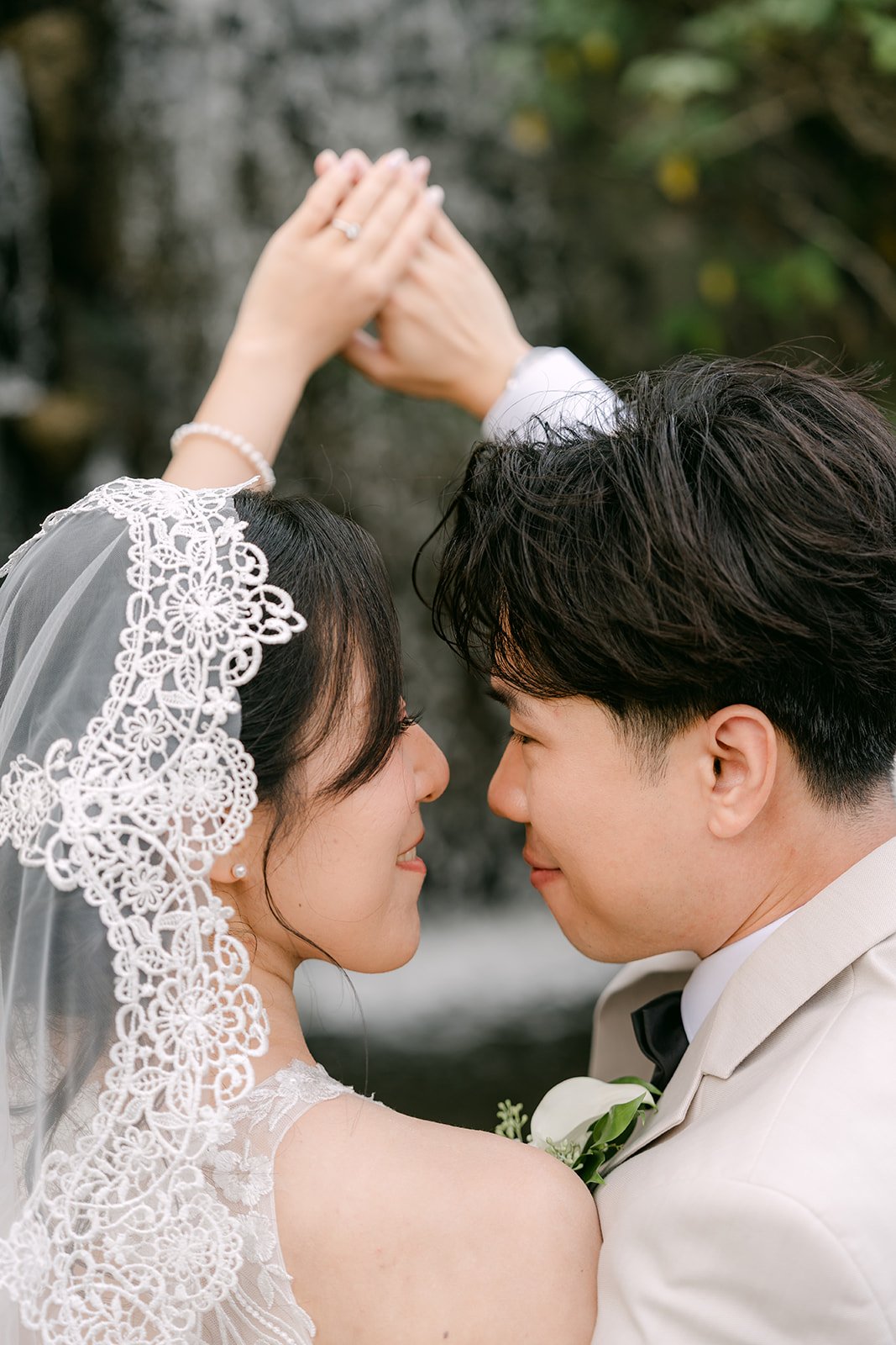 Elaine making a heart over Wen's head as their foreheads touch.
