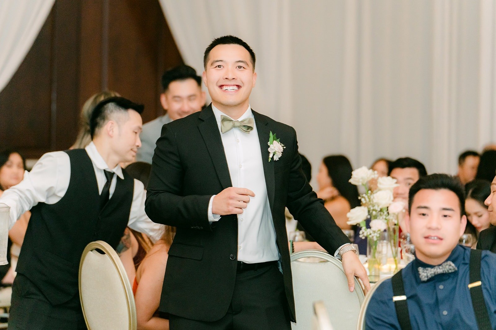 A groomsman raising a toast to the couple